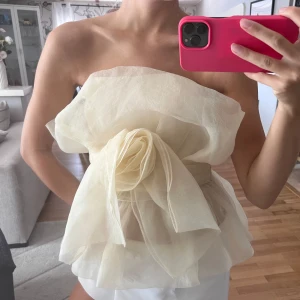 Krämvit axelbandslös tubtopp med volang och rosettdetalj - Zara tubtopp med fin ros.