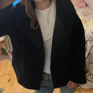 Svart kappa med stora slag och knappar - Säljer en super fin mörk blå/ marinblå kappa från Design by sí med stora slag och dubbelknäppning framtill. Jackan har en rak och något oversized passform, långa ärmar och är tillverkad i ett tjockare material som passar bra till kyligare dagar. Storlek xs/s. Hör av dig om du har frågor eller funderingar💕