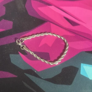 Silver armband - Stilrent armband i silverfärg med tvinnad kedja som ger en cool och modern look. Perfekt att bära ensam eller tillsammans med andra smycken för en personlig stil. Lätt att ta på med smidig låsning. Passar både tjejer och killar som gillar minimalistiska accessoarer. Från guldfynd ny pris på 600