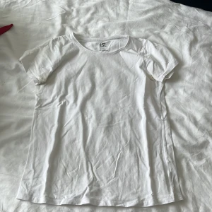 Vit basic t-shirt från 157 - Enkel och stilren vit t-shirt från 157 med rund halsringning och korta ärmar. Tillverkad i mjuk bomull med lite stretch för extra komfort. Perfekt att matcha med jeans eller shorts för en clean look.