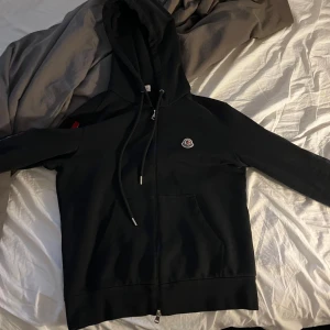 Moncler hoodie - Svart hoodie från Moncler med dragkedja, storlek M passar mig perfekt som är 184 väger 84 kg för fler bilder eller information kring hoodien är det bara höra av sig. Fraktar alltid inom 24h PS HAR ÄKTHETSBEVIS