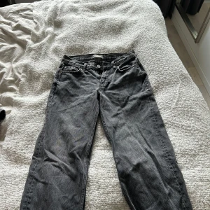 Grå, lågmidjade jeans från Gina tricot - Säljer ett par grå, lågmidjade jeans i storlek 32, de är vida i modellen.