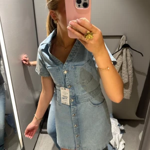 Jeansklänning med kort ärm och knappar - Säljer en super snygg ljusblå jeansklänning. helt ny. perfekt t sommarn. nypris 500🥰