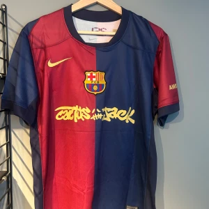 FC Barcelona x Cactus Jack fotbollströja - Säljer en FC Barcelona x Cactus Jack matchtröja i rött och blått med gul Nike-logga och klubbmärke. Tryck med Lamine Yamal och nummer 19 på ryggen. Kortärmad modell i lätt och ventilerande material. Helt ny med tagg en replika 