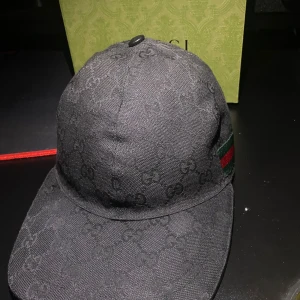 Äkta Svart keps från Gucci XS - Svart Gucci-keps – knappt använd  Säljer min svarta Gucci-keps som jag fick i julklapp, har haft den i ca 6 månader. Den är i mycket fint skick och kan också passa dig som vanligtvis har storlek M.  Säljer den eftersom jag rensar garderoben – inget fel på kepsen!  Pris kan diskuteras vid snabb affär. PRISET ÄR INTE HUGGET I STEN!