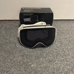Vita skidglasögon Cross Sportswear - Snygga vita skidglasögon från Cross Sportswear, modell SO Aspen Frame II. De har mörka, rökfärgade linser (kategori 3) med UV400-skydd och anti-fog behandling. Justerbart elastiskt band och mjuk trippellagers skum för extra komfort.