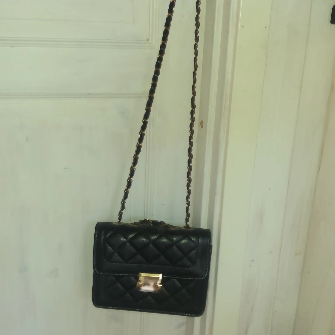 Svart quiltad axelväska med gulddetaljer