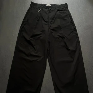 Eytys  - Scout Wide Leg Straight Trousers - Nypris ca 3000 SEK.  Unisex, passar dam storlek 38, herr storlek 48.  Ikoniska byxor från Eytys i modellen Scout. Unisex design med en stilren, något oversize silhuett och breda ben. Svarta med diskreta detaljer och högkvalitativ finish - perfekt för dig som gillar minimalistiskt, skandinaviskt mode med edge