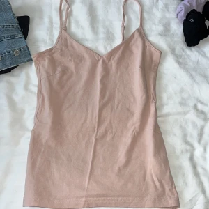Beige linnetopp från 157, storlek S - Säljer en enkel och stilren beige linnetopp från 157 i storlek S. Toppen har smala axelband och v-ringad hals, perfekt för varma dagar. Tillverkad i mjuk bomull med lite stretch för extra komfort.