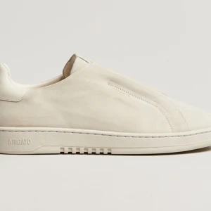 Beige sneakers från Axel Arigato - Laceless beige sneakers från Axel Arigato i mocka. Skorna är använda två gånger och har ett litet tecken av användning. Dessa skor köptes för 2600 kr