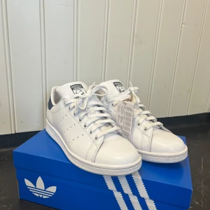 Adidas stan Smith skor  - Säljer mina älskade stan Smith skor då jag insåg försent att de var alldeles för små för mig.  Endast testade här hemma på gården där av smutsiga under sulan och lite rätt rynklig i lädret men fortfarande i originalskick.  Stl 40, orginallåda medföljer.  Köpta för 1349kr.