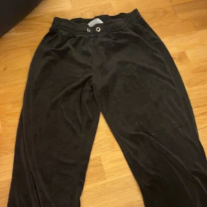 Svarta mjukisbyxor från Gina Tricot - Svarta mjukisbyxor från Gina Tricot i storlek S. Byxorna har resår i midjan och är gjorda i ett mjukt, skönt material som känns riktigt chill. Perfekta för en avslappnad look eller när du bara vill vara bekväm hemma.