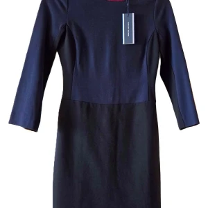 Oanvänd Klänning Tommy Hilfiger marinblå Ny prislapp strl 36 / S - Helt ny marinblå-svart klänning med vinröd krage från Tommy Hilfiger. Material: Viskos & polyester . Storlek: 36/10.  Skick: helt ny / oanvänd (prislappen kvar, se bild). Kragen är vinröd, överdelen och ärmarna fram- och bak är marinblå, i övrigt svart. (Svårt att fota baksidan dessvärre, pga. färgerna och ljusföruttsättningar.)  Från djur- samt rökfritt hem.