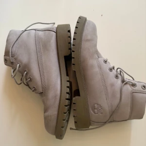 Grå Timberland kängor i skinn/mocka - Snygga grå Timberland kängor i skinn/mocka med grov sula och klassisk snörning. Ikonisk logga på sidan och slitstark design, perfekta för höst och vinter. Håller värmer oerhört bra. Säljes pga dem har blivit för små för mig. De är i otroligt bra skick. Pris kan diskuteras vi smidig affär. 