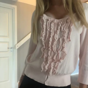 Ljusrosa kofta med volangdetaljer - Supersöt rosa kofta i storlek M men jag skulle säga att den även passar S.