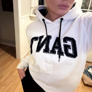 Vit hoodie från GANT med mörkblått/svart tryck - Säljer min favorithoodie från GANT med broderad logga framtill och svarta snören i huvan. Klassisk modell med lång ärm och mjukt material, perfekt för chill dagar. Snygg och enkel att matcha till jeans eller mjukisbyxor. Passar en S/M💖💖💖