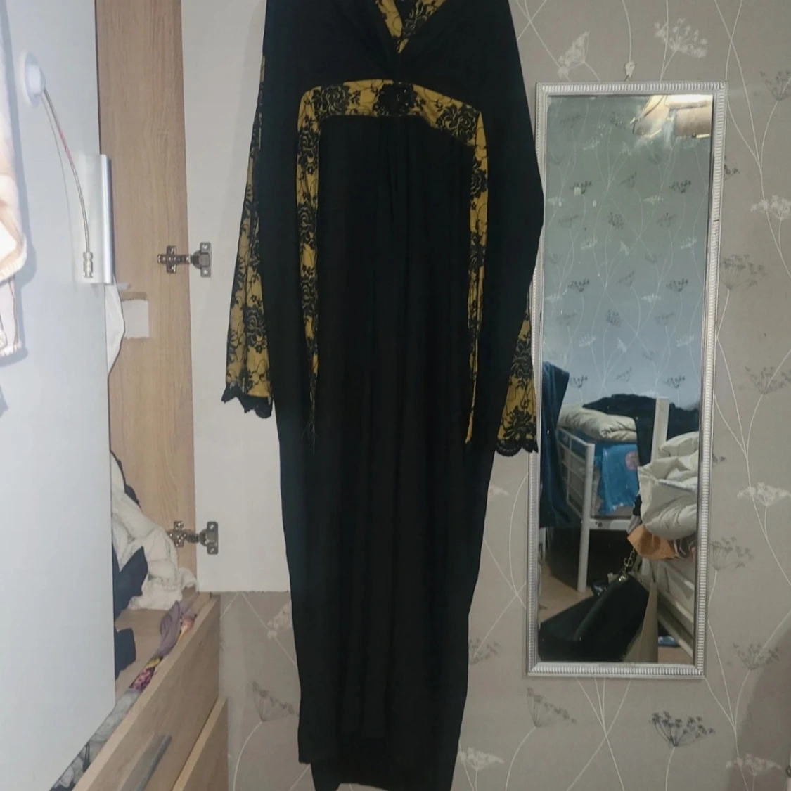 Svart långklänning med gula spetsdetaljer