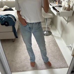 ljusblå raka jeans - Säljer det populära jeansen från Zara. Storlek 36!  De har rak passform, hög midja och fem fickor. Jeansen är tillverkade i robust bomullsdenim och har den ikoniska läderpatchen bak i midjan. Perfekta för en avslappnad och tidlös look.