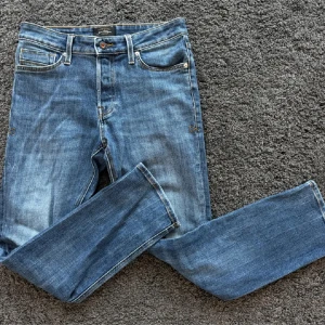 Slim straight jeans i blå denim - Blå jeans med klassisk femficksdesign och snyggt slitna detaljer. Modellen är slim straight med raka ben och smal passform. Jeansen har orange kontrastsömmar och är tillverkade i mjuk denim för en bekväm känsla. W29 L 30
