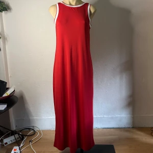 Röd maxiklänning från Next i sportig retromodell Stl 38/M Fint skick  -  Röd maxiklänning från Next i sportig, minimalistisk stil. Inköpt second hand och passade mig tyvärr inte. Alla lappar saknas, uppskattad storlek är medium. Ärmlös modell med vita kontrastband runt halsringning och ärmhål. Tyget känns mjukt och faller fint – perfekt både till vardags och uppklätt.  Prutning accepteras inte, men jag erbjuder rabatt vid köp av flera plagg. Jag rensar garderoben och rear ut allt – passa på att kika på mina andra annonser!