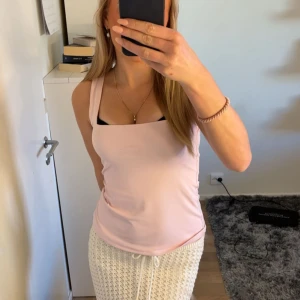 Ljusrosa linnetopp med breda axelband - Säljer en ljusrosa linnetopp med breda axelband och rak halsringning. Toppen är enkel och stilren, perfekt att matcha med både kjol och jeans. Mjuk och skön känsla, passar dig som gillar en clean look.