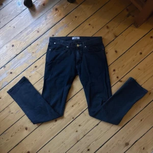 Mörkblå Acne Max/Man Ray jeans 31/32 - Snygga mörkblå jeans från Acne Studios, modell Max/Man Ray. Klassisk femficksdesign, raka ben och normal passform. Tillverkade i bomull med lite elastan för extra komfort. Perfekta för dig som gillar stilrena och tidlösa jeans.