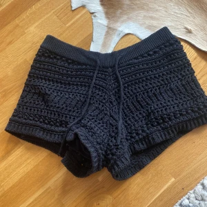 Svarta stickade shorts med snörning - Snygga svarta stickade shorts med coolt virkat mönster och snörning i midjan. 