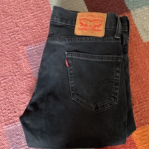 Svarta Levi's jeans 511 - Klassiska svarta jeans från Levi's modell 511 med rak passform och femficksdesign. Byxorna har en tydlig läderpatch bak i midjan och röd Levi's-tag på bakfickan. Perfekta för en stilren och tidlös look. Hojta till om frågor, prisförslag eller något annat. Byten funkar