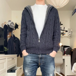 stickad hoodie med fleece huva - Är egentligen xs men passar lite större. Mysig stickad hoodie med huva och dragkedja. Insidan är fodrad med mjuk fleece för extra värme. 173cm och 56kg på bilden. Hör av er vid minsta lilla fråga.