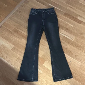 Svarta bootcut jeans med vita sömmar och fjärilar på fickorna - (Meddela innan köp) Säljer ett par svarta/mörkgråa mid waist bootcut jeans med vita kontrastsömmar och snygga fjärilsbroderier på bakfickorna. Dom här jeansen är verkligen jättesnygga men dom passar bara inte på mig❤️Dom är i superbra skick eftersom att jag bara använt några få gånger och jag köpte dom nyligen.