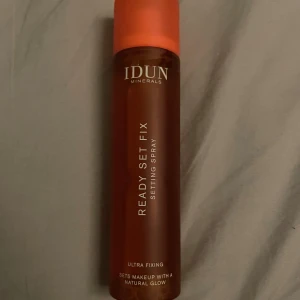 IDUN Minerals Ready Set Fix Settingspray - IDUN Minerals Ready Set Fix är en settingspray som fixerar sminket och ger en naturlig glow. Flaskan är brun med orange lock och innehåller 100 ml. Produkten är vegansk och passar för att hålla makeupen på plats hela dagen.