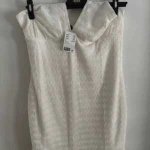 Vit spetsklänning - Säljer en vit klänning med spets. Helt ny med tags, säljer då jag köpte fel storlek 🥲Klänningen är har djup v-ringning och har ett elegant mönster i tyget. Perfekt för sommarens tillfällen eller studentfirande. 