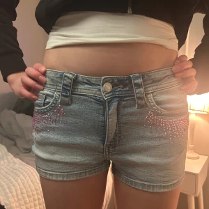 Jeansshorts med rosa stenar  - Super snygga jeansshorts från H&M med rosa stenar på. Dom är egentligen från barnavdelningen i en storlek 152 men skulle säga att dom även passar en xxs/xs💓💕