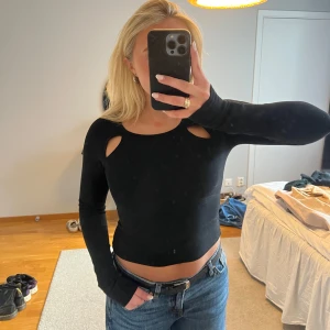 Svart croppad topp med cut-outs - croppad långärmad topp från Gina Tricot. Toppen har snygga cut-outs vid axlarna och en tight passform. 🩷🩷