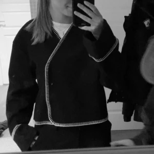 Svart kappa med vita detaljer  - Säljer min super fina svarta kappa med vita detaljer. En tunn kappa som passar perfekt en sen sommar kväll 🫶🏼🫶🏼 