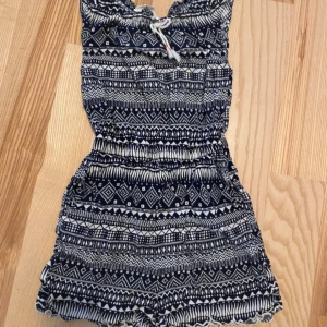 Mönstrad byxdress - Supersöt byxdress med grafiskt mönster. Resår i midjan och knytning upptill. Perfekt för varma dagar och enkel att styla med sneakers eller sandaler.