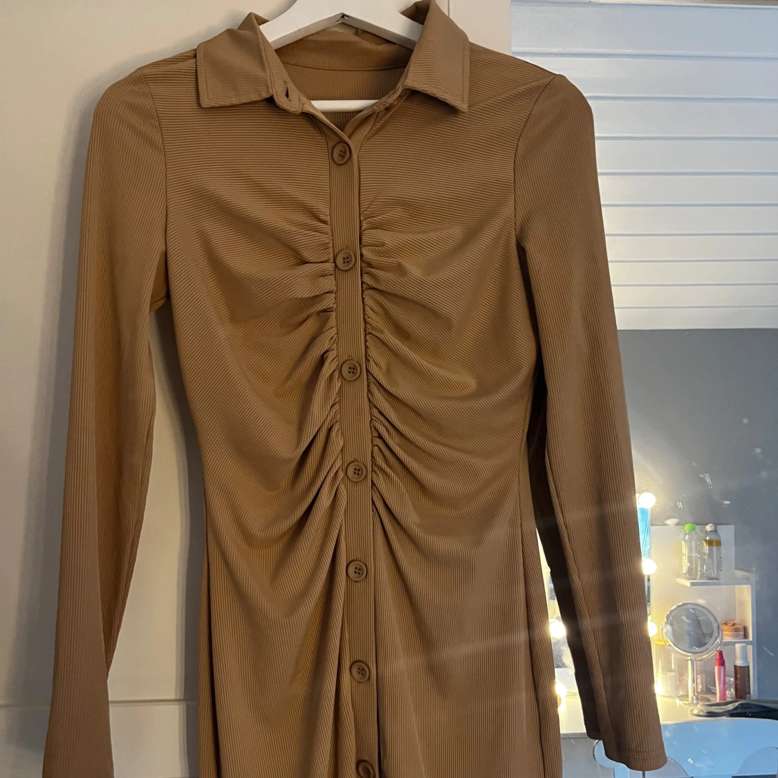 Beige långärmad klänning med knappar och rynk