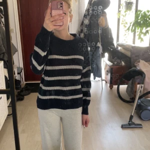 Mörkblå och vit randig stickad tröja från 157 - 50kr!! Säljer en stickad tröja från 157 i mörkblått och vitt med breda horisontella ränder. Tröjan har rund halsringning och långa ärmar. Perfekt för kyligare dagar och enkel att styla till olika outfits.