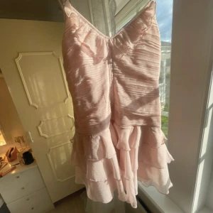 Ljusrosa volangklänning med smala axelband - Supersöt ljusrosa klänning med smala axelband och volangdetaljer. Bra skick. Skriv för fler bilder ☺️