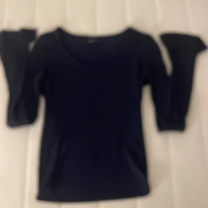 Mörkblå långärmad topp från Gina Tricot - Säljer en mörkblå långärmad topp från Gina Tricot. Tröjan har en rund halsringning och är figurnära i modellen. Perfekt att styla med jeans eller kjol för en enkel och stilren look.