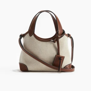 Väska från H&M🤎 - Säljer denna jättefina väska ifrån H&M! Använd fåtal gånger! Jag gjorde ett till hål i bandet då de va väldigt långt, inte jättesnyggt men det är inget som syns när man använder väskan🩷