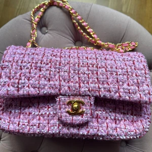 Rosa tweed axelväska  - Säljer en rosa axelväska i tweed. två olika nyanser i materialet.  med guldiga detaljer och kedjerem. Väskan har klassiskt spänne framtill och insida i rosa läder. Perfekt för dig som vill ha en statementväska med lyxig känsla. Helt nyinköpt men ångrade mig därför säljer jag. Riktig top quality. 