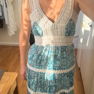 Blå och vit sommarklänning med spetsdetaljer - Säljer jättefin klänning köpt i Grekland 