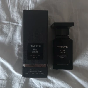 Tom Ford Oud Wood Eau de Parfum 50ml - Lyxig parfym från Tom Ford i doften Oud Wood. Flaskan är svart med elegant design och rymmer 50 ml. Kommer med originalförpackning. Perfekt för dig som gillar exklusiva och träiga dofter. Typ helt full. Använd ca 3 gånger.