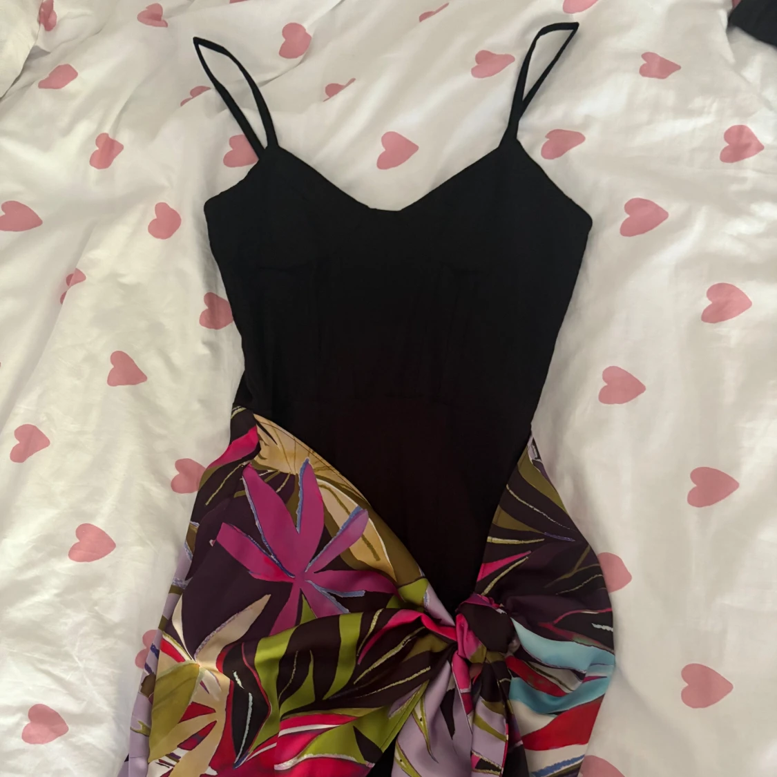 Svart klänning med färgglad blommig kjol och knyt