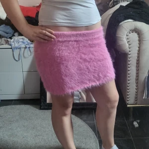 Rosa fluffig kjol - Säljer en supermjuk och fluffig rosa kjol med kort längd. Kjolen har en rak passform och är perfekt för dig som vill sticka ut med en unik look. Materialet är syntetiskt och ger en mysig känsla.