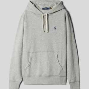 Grå hoodie från Polo Ralph Lauren - Säljer en klassisk grå hoodie från Polo Ralph Lauren med broderad logga på bröstet. Tröjan har huva och en stor magficka framtill. Perfekt för en avslappnad stil. Pris kan diskuteras och hör av dig om du undra nått 