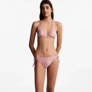 Rosa mönstrad bikini från Mango - Säljer en söt rosa bikini med vitt blommigt mönster. Överdelen är trekantsmodell med knyt i nacken och ryggen, och underdelen har knyt i sidorna. Helt ny i originalförpackning, missade att lämna tillbaka i tid! Nypris 400kr och storlek M (står L men det är Mango Teen där L=M)