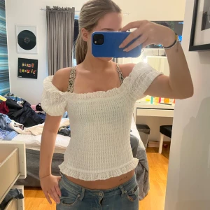 Vit offshoulder topp med volang - Säljer en söt vit offshoulder topp. Prislappen kvar. Storlek S 