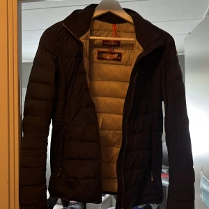 Svart pufferjacka från Parajumpers - Säljer en svart pufferjacka från Parajumpers med beige insida. Jackan har lång ärm, dragkedja och quiltad design. Perfekt för kyliga dagar och har en klassisk, sportig look. Märkesdetaljer på insidan.